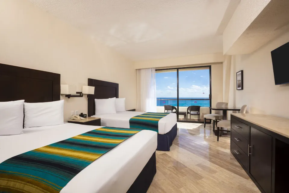 Standard Ocean View room with two beds and balcony view at Crown Paradise Club Cancun.