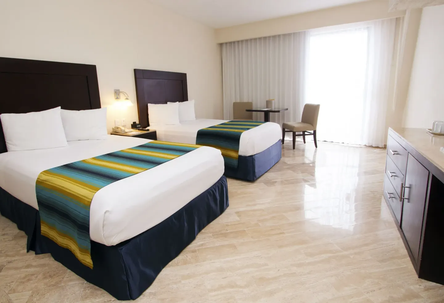 Standard Ocean View room with two beds and bright window at Crown Paradise Club Cancun.