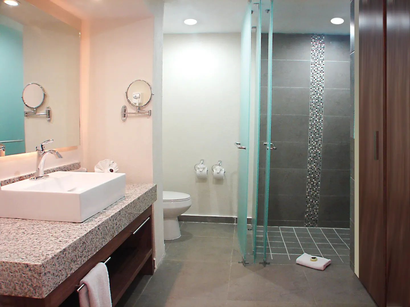 Bathroom with granite vanity and walk-in shower at Crown Paradise Club Puerto Vallarta.
