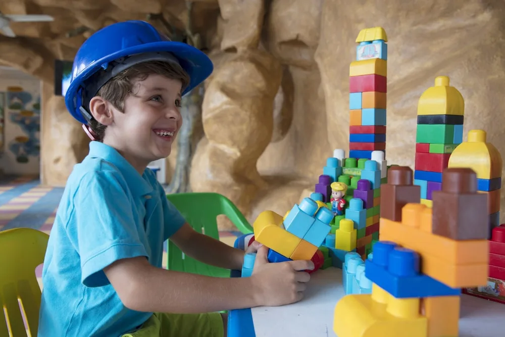 Child playing with colorful blocks in the kids area at Crown Paradise Club Puerto Vallarta.