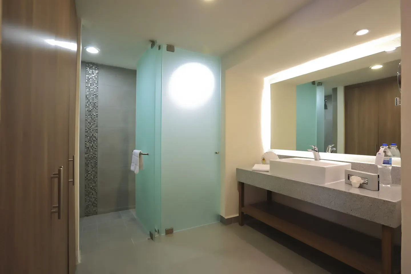 Modern bathroom with glass shower and wide vanity at Crown Paradise Club Puerto Vallarta.