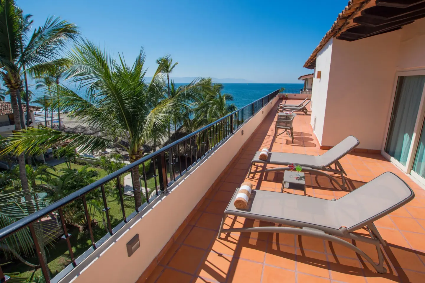 Ocean-view balcony with loungers at Crown Paradise Club Puerto Vallarta.