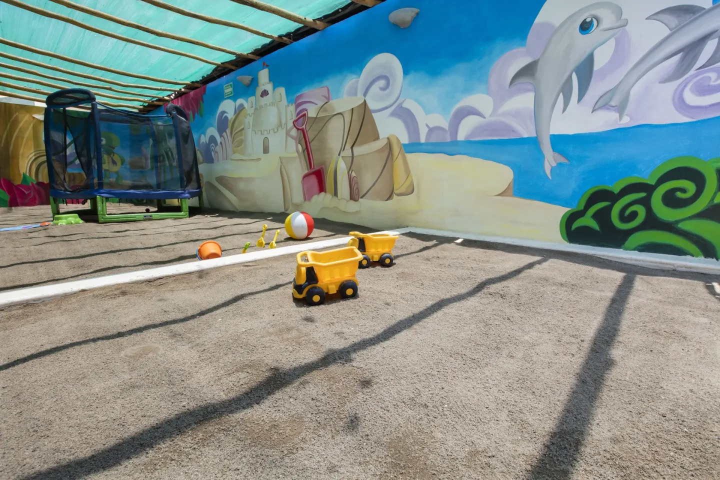 Outdoor children’s play area with beach mural at Crown Paradise Club Puerto Vallarta.