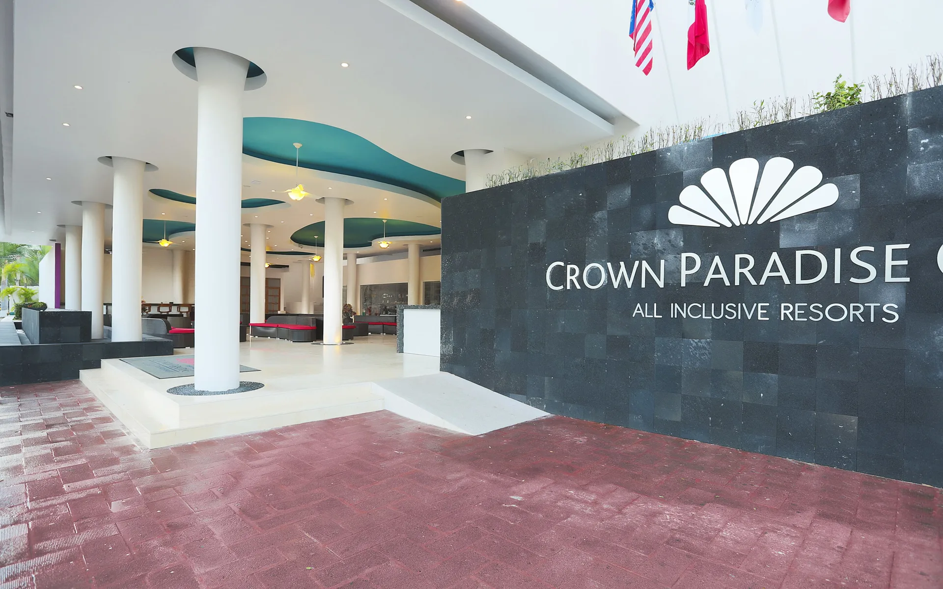Resort entrance wall and covered lobby drive at Crown Paradise Club Puerto Vallarta.