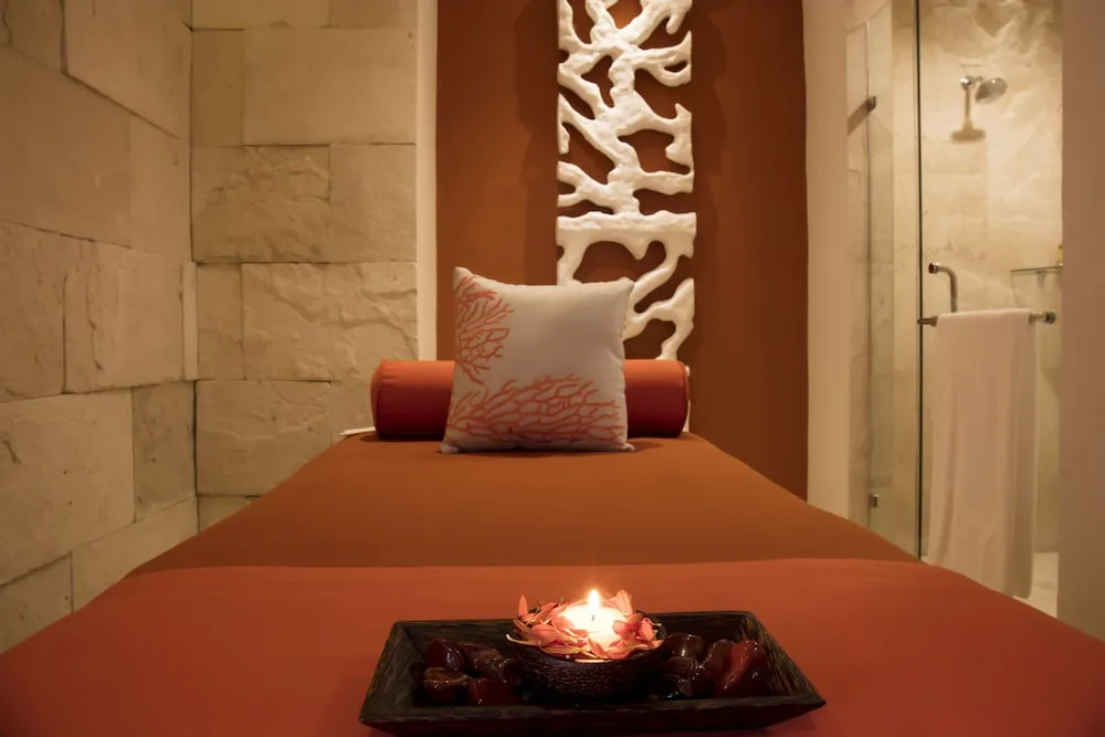 Spa treatment room with massage bed and candle at Crown Paradise Club Puerto Vallarta.