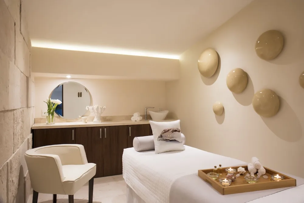 Spa treatment room with massage bed and candles at Crown Paradise Club Puerto Vallarta.