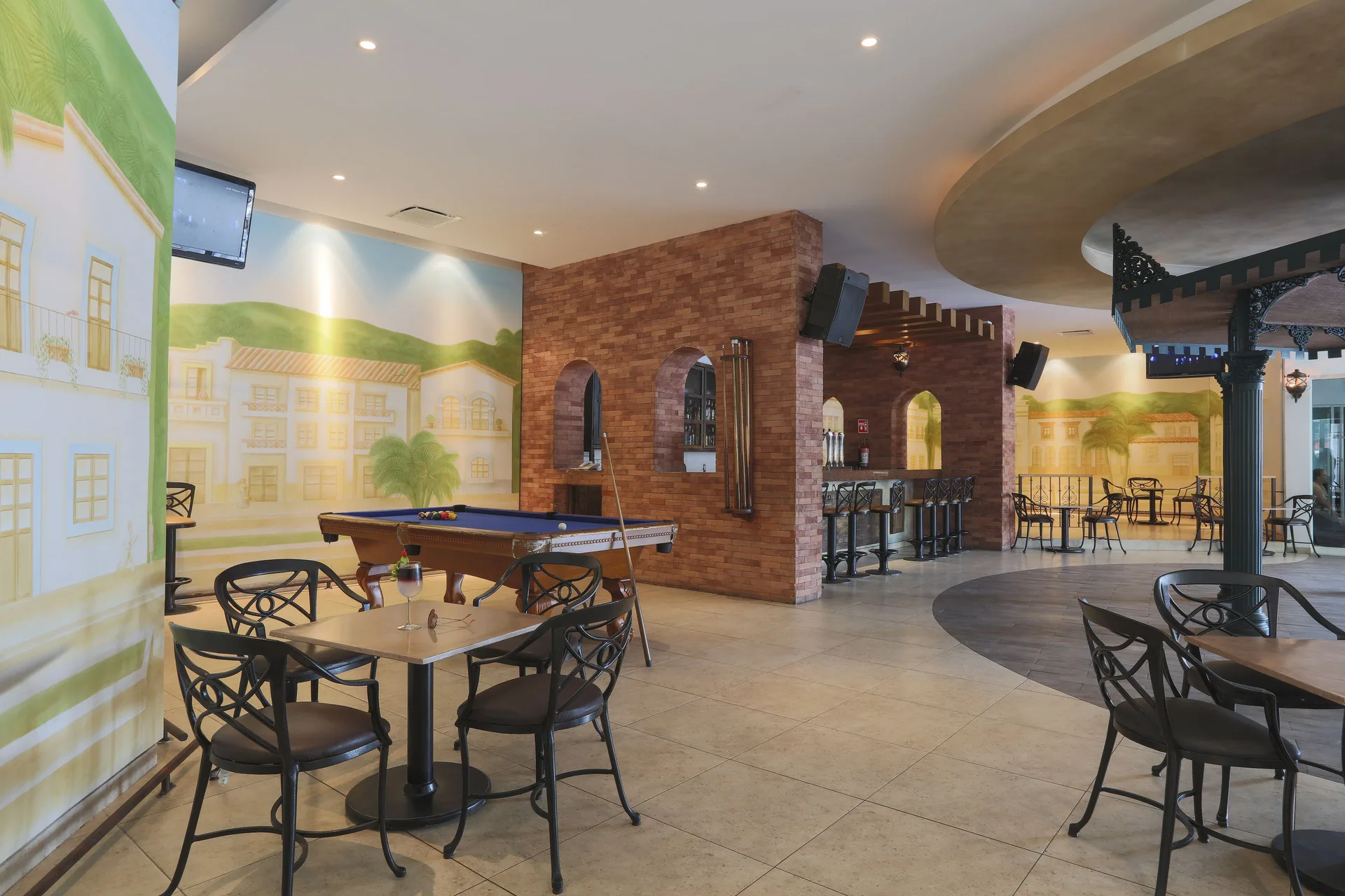 Indoor lounge with pool table and café seating at Crown Paradise Club Puerto Vallarta.