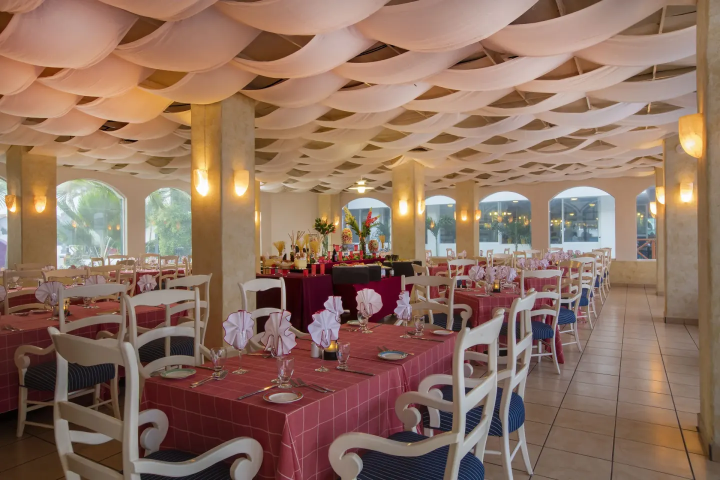 Restaurant dining room with pink tablecloths at Crown Paradise Club Puerto Vallarta.
