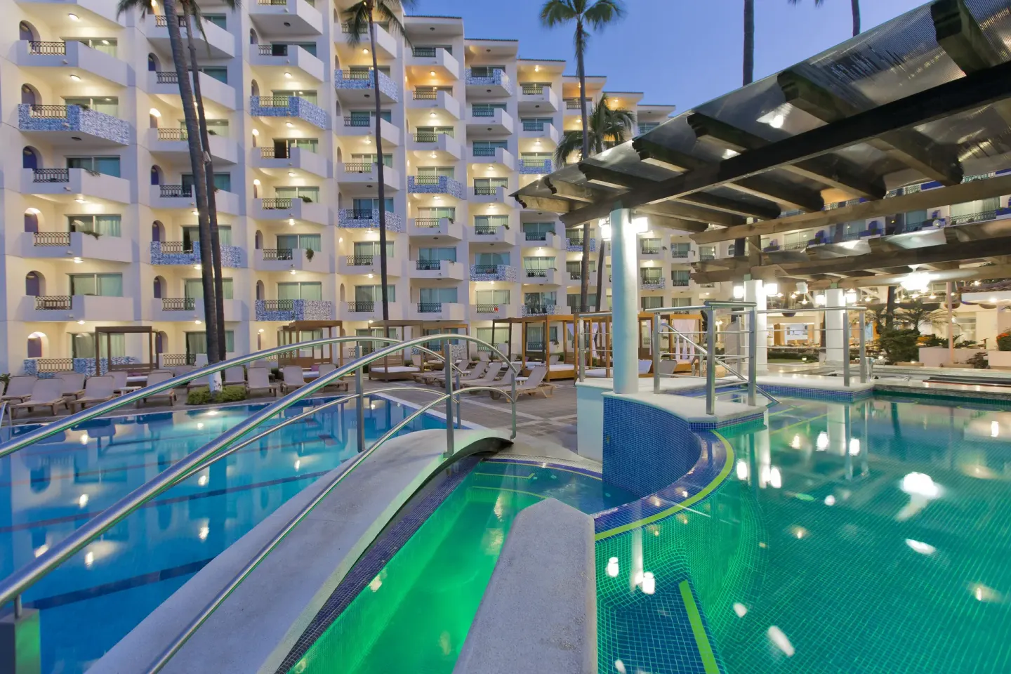 Evening pool area with bridge and resort balconies at Crown Paradise Golden Resort.