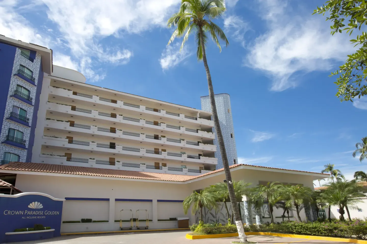 Exterior hotel building with balconies and palm trees at Crown Paradise Golden Resort.