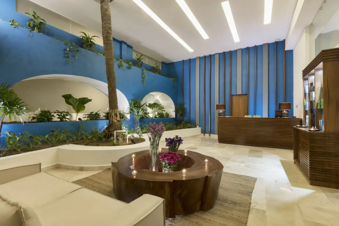 Lobby seating area with blue walls and indoor plants at Crown Paradise Golden Resort.