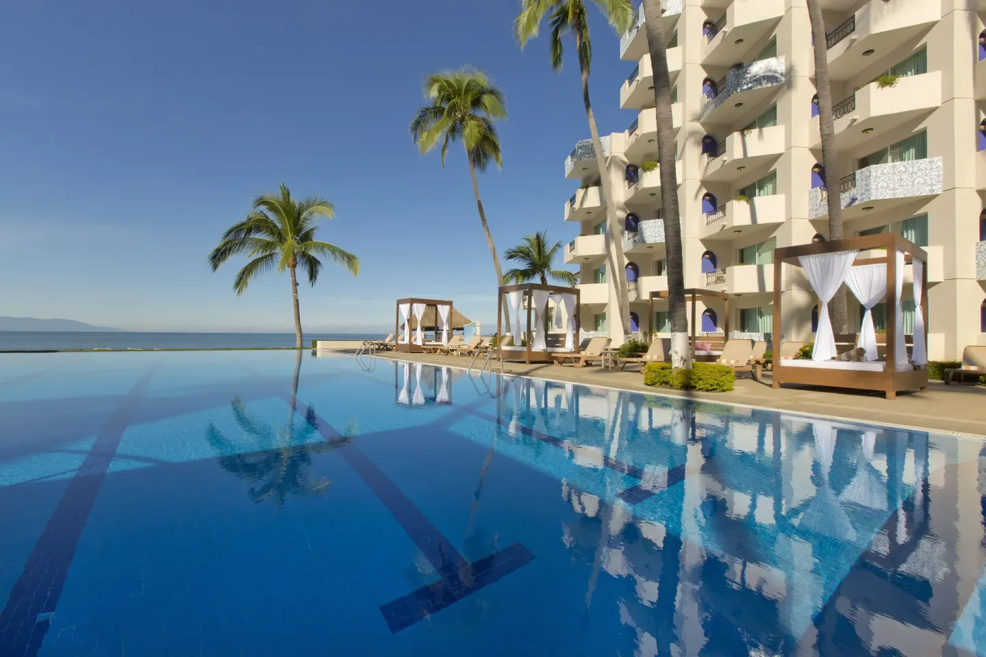 Pool, cabanas, palms, and balconies at Crown Paradise Golden Resort.