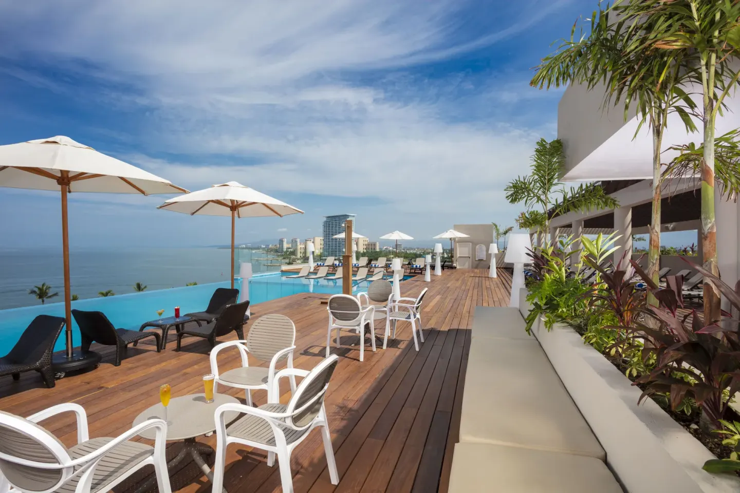 Rooftop pool deck with umbrellas and ocean view at Crown Paradise Golden Resort.
