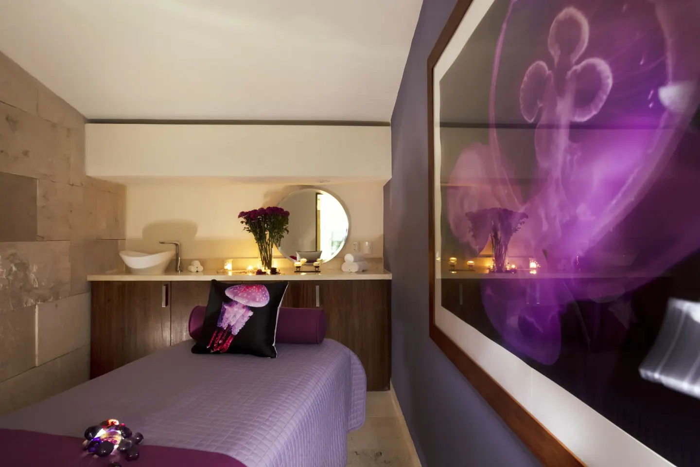Spa treatment room with purple decor, candles, and floral artwork at Crown Paradise Golden Resort.