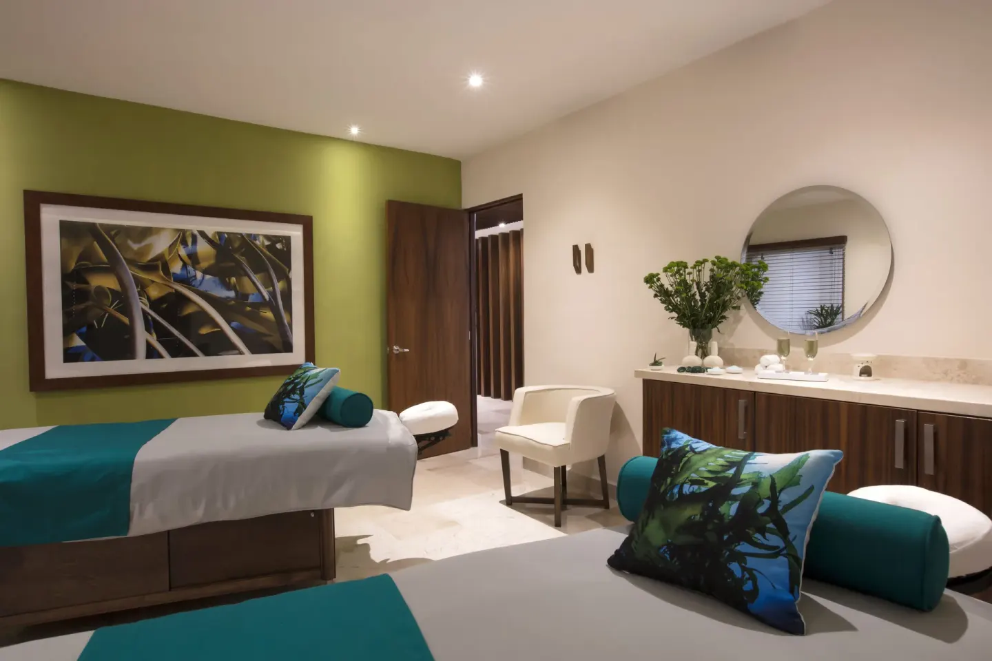 Spa room with two treatment beds, teal accents, and a vanity at Crown Paradise Golden Resort.