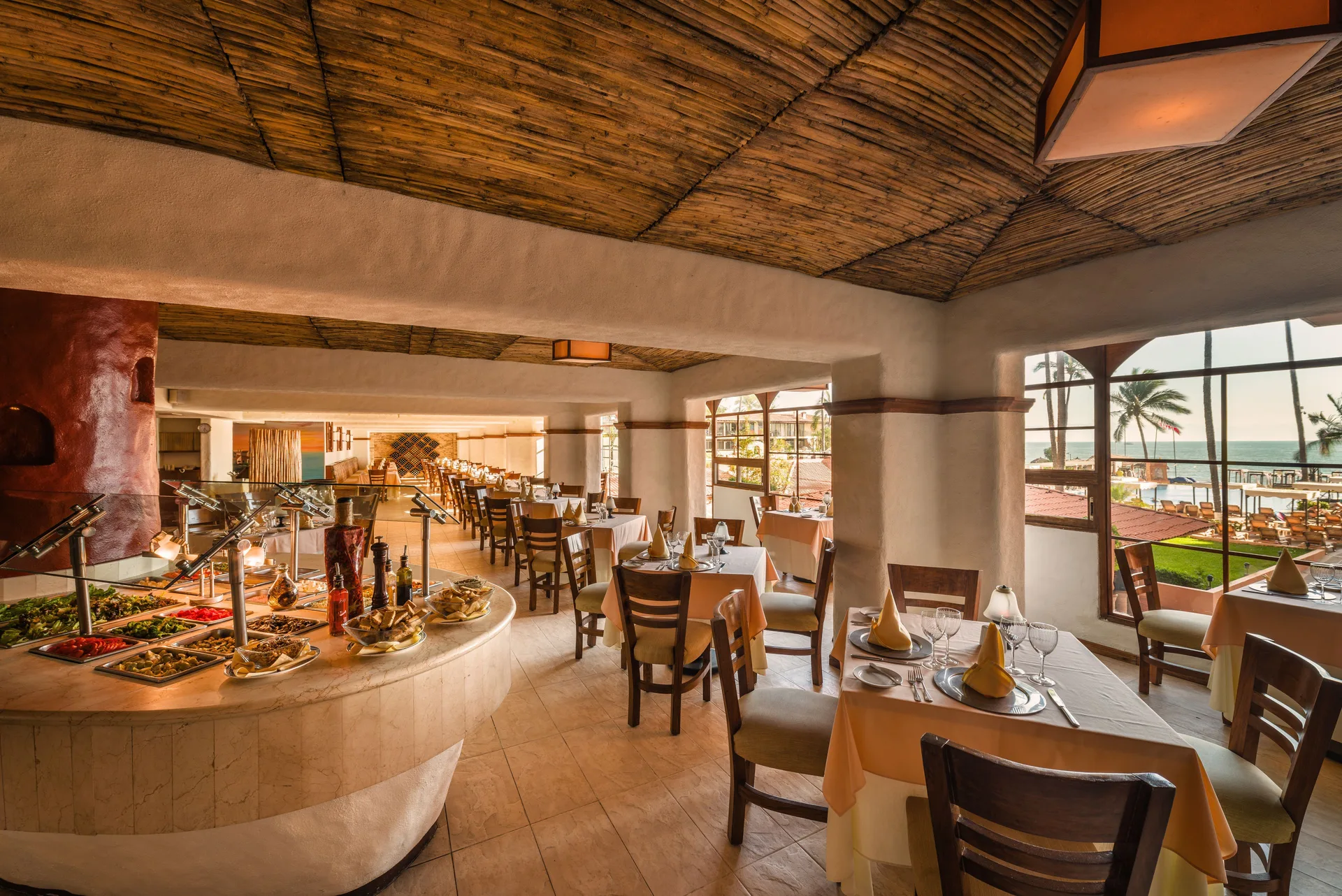 Ocean-view dining room with buffet and set tables at Crown Paradise Golden Resort.