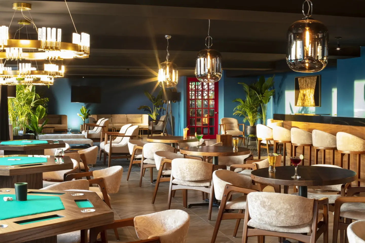 Sports bar seating with game tables and pendant lighting at Crown Paradise Golden Resort.