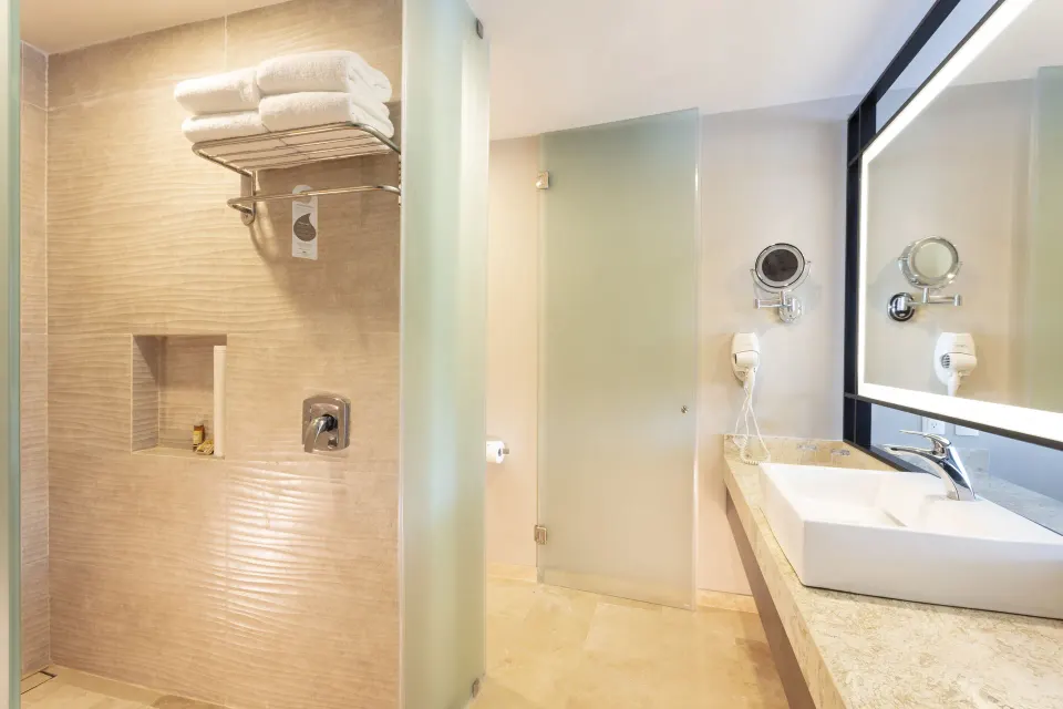 Deluxe Room bathroom with shower, towels, and sink at Crown Paradise Golden Resort.