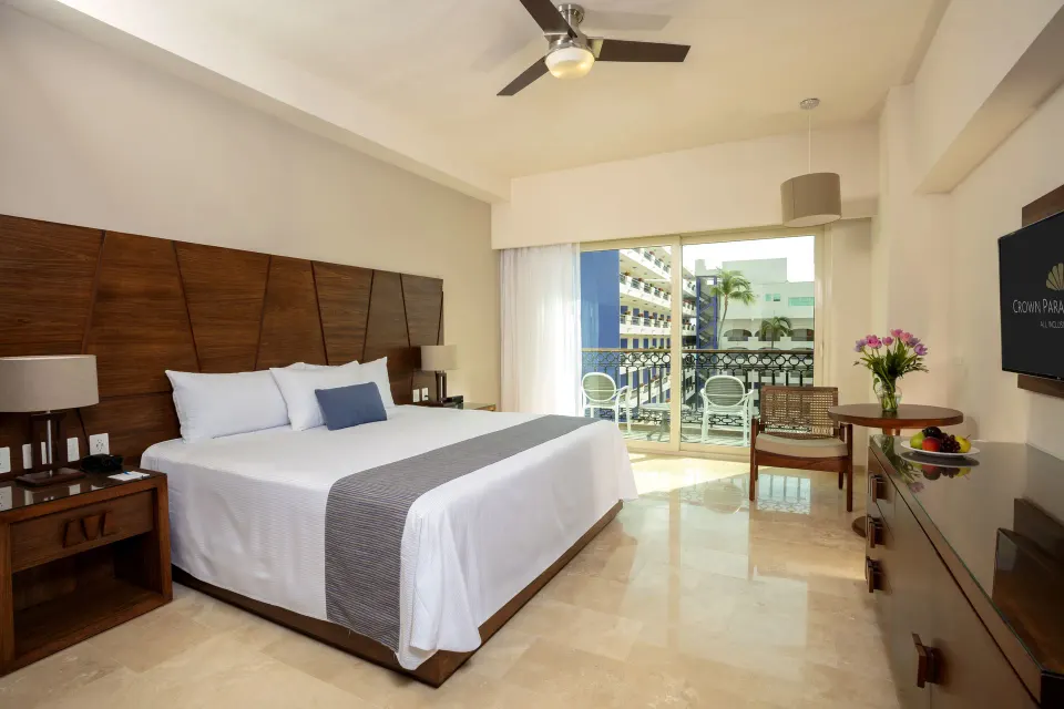 Deluxe Room king bed with balcony seating at Crown Paradise Golden Resort.
