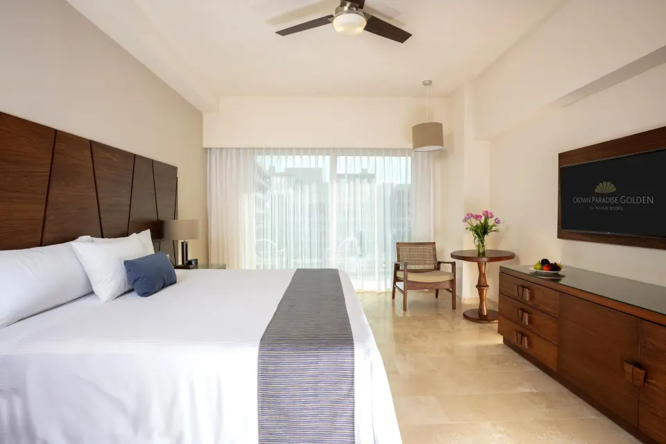 Deluxe Room king bed with TV and sitting area at Crown Paradise Golden Resort.