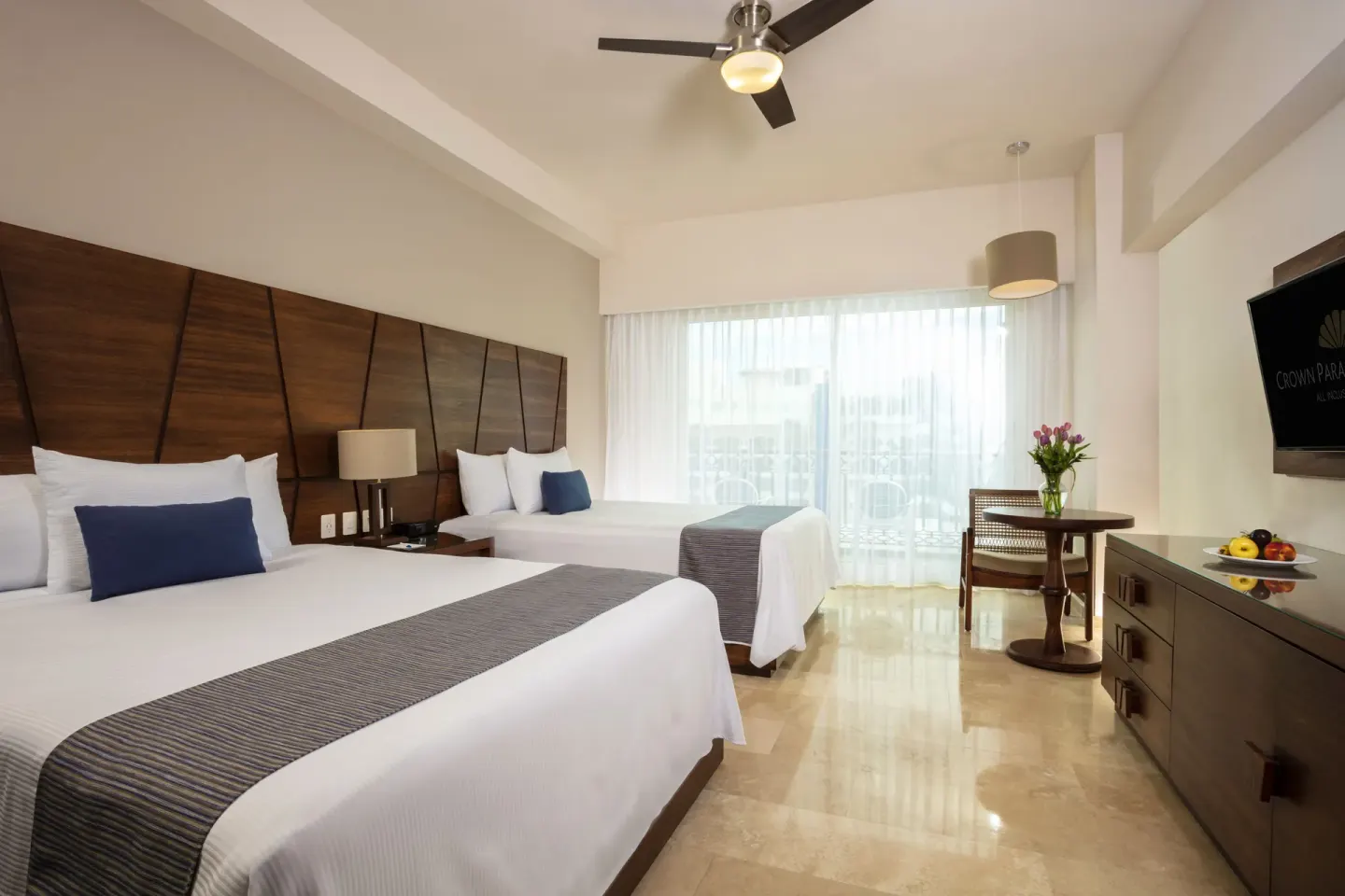 Deluxe Room with two beds and balcony doors at Crown Paradise Golden Resort.
