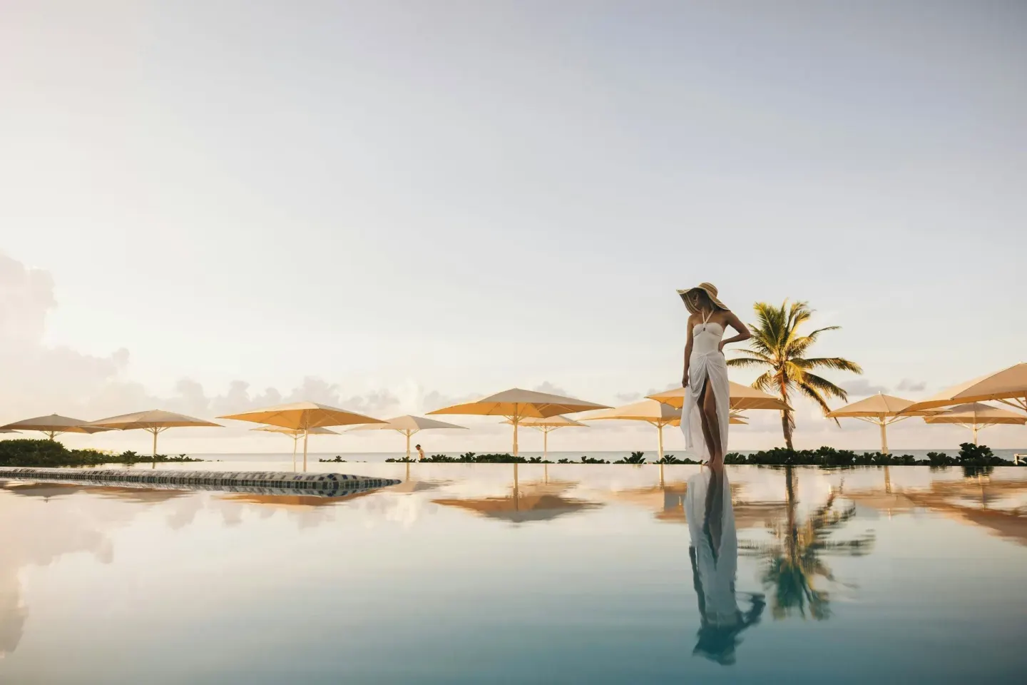 Infinity pool with umbrellas and a palm at Curacao Marriott Beach Resort.