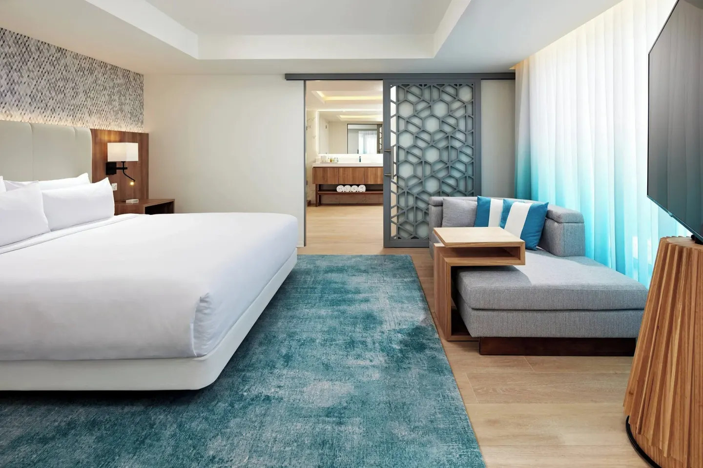 King guest room with sofa seating and open vanity area at Curacao Marriott Beach Resort.