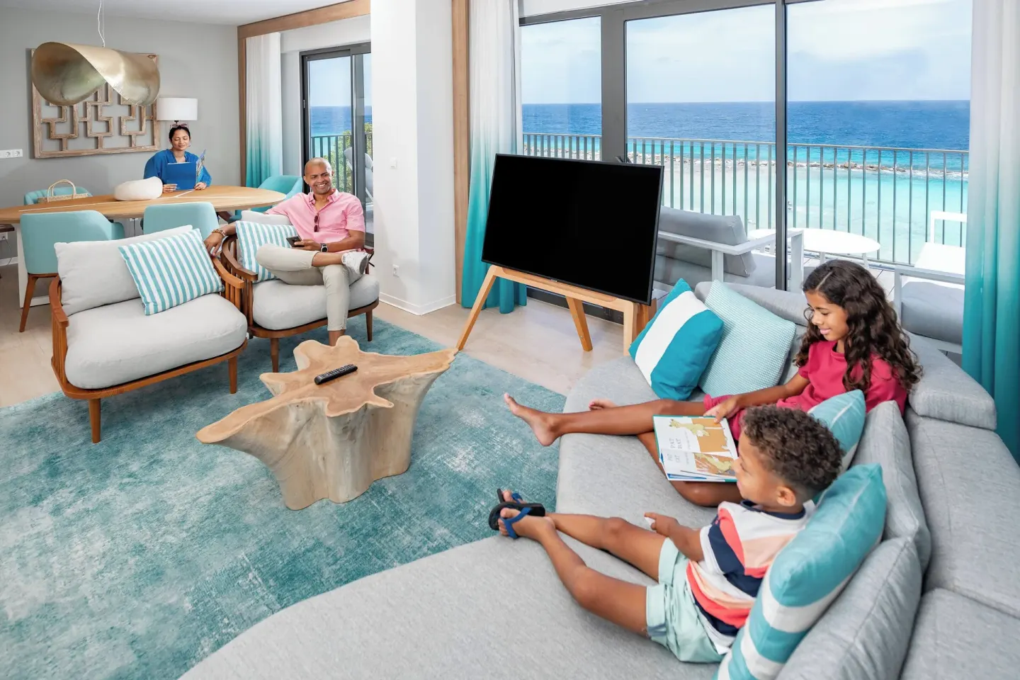 Family relaxing in an oceanfront suite lounge at Curacao Marriott Beach Resort.