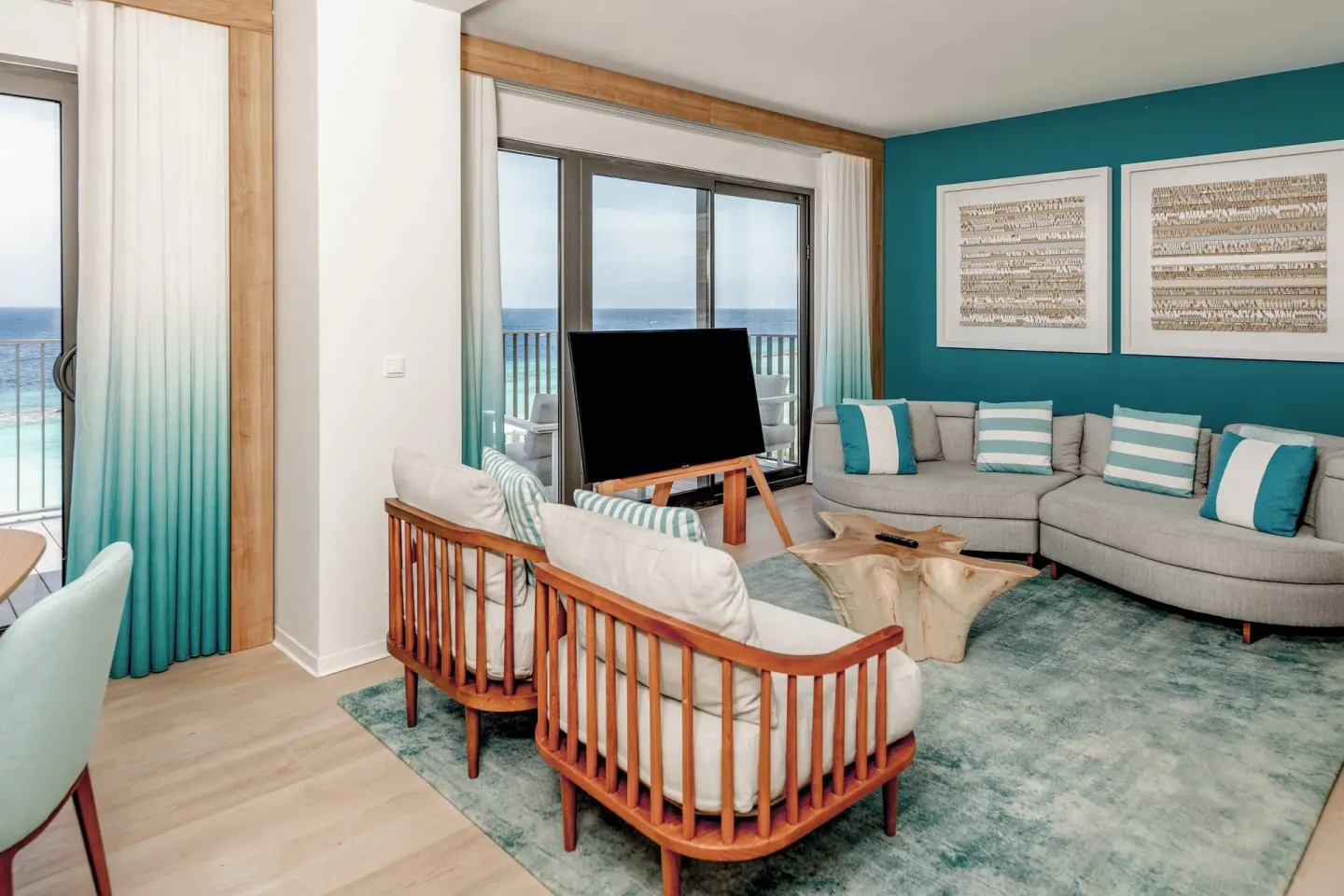 Oceanfront suite lounge with sofas, armchairs, and balcony at Curacao Marriott Beach Resort.