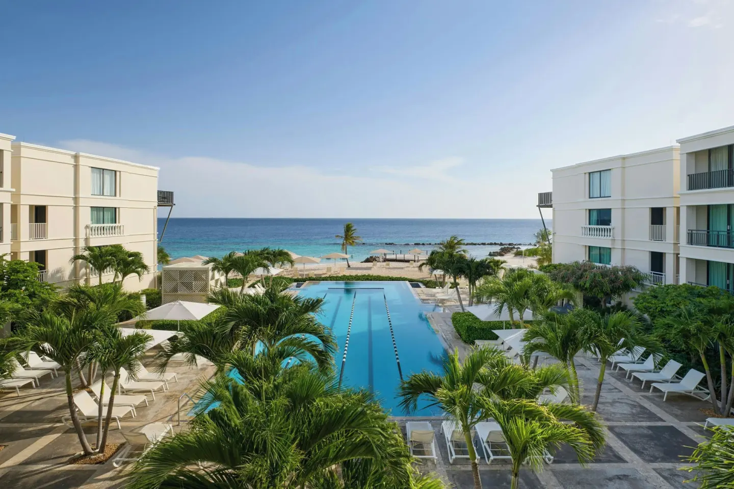 Elevated view of the pool, palms, beach, and ocean at Curacao Marriott Beach Resort.