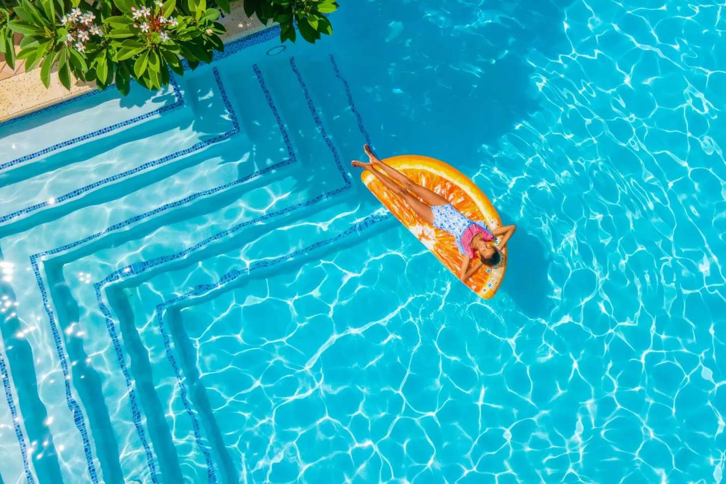 Guest floating on an orange raft in the pool at Curacao Marriott Beach Resort.