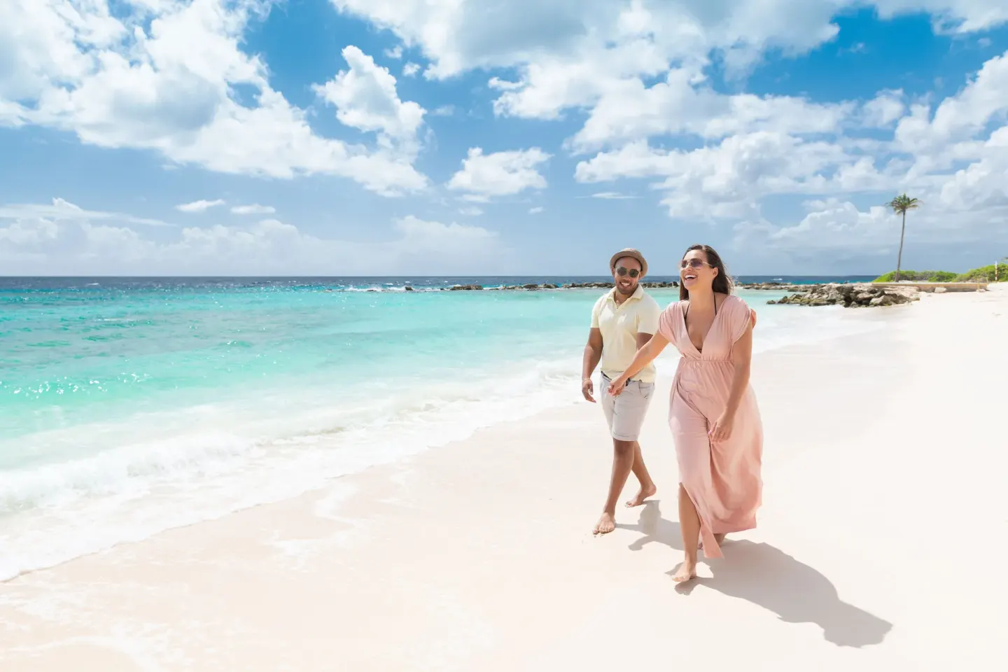 Couple walking on the white sand beach at Curacao Marriott Beach Resort.