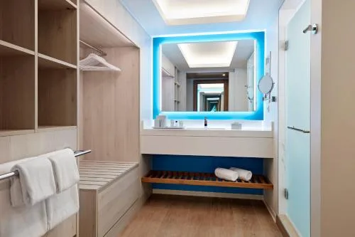 Partial Ocean View bathroom at Curacao Marriott Beach Resort with illuminated mirror and towel storage.
