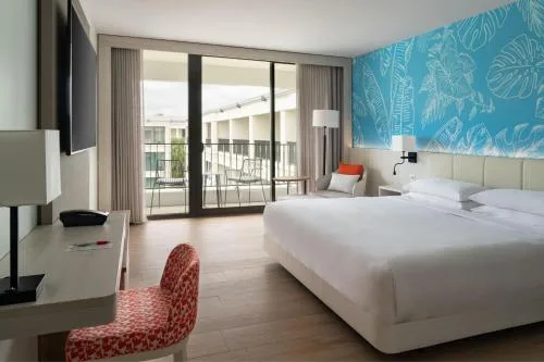 Partial Ocean View king bed room at Curacao Marriott Beach Resort with blue wall and balcony access.