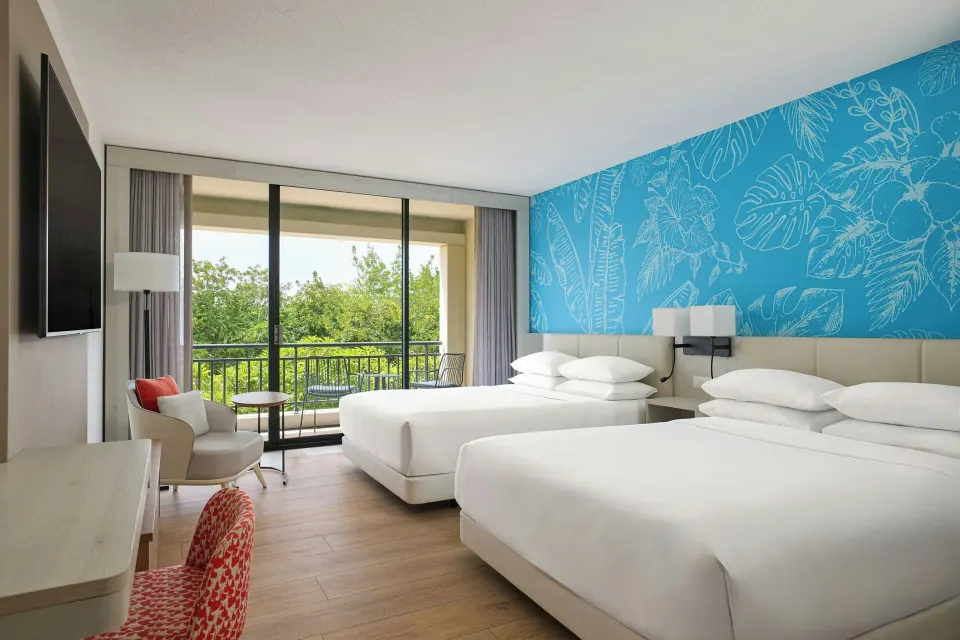 Two-bed guest room with blue accent wall at Curacao Marriott Beach Resort.