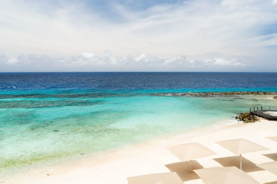 Oceanfront beach view from a room at Curacao Marriott Beach Resort with turquoise water and umbrellas.
