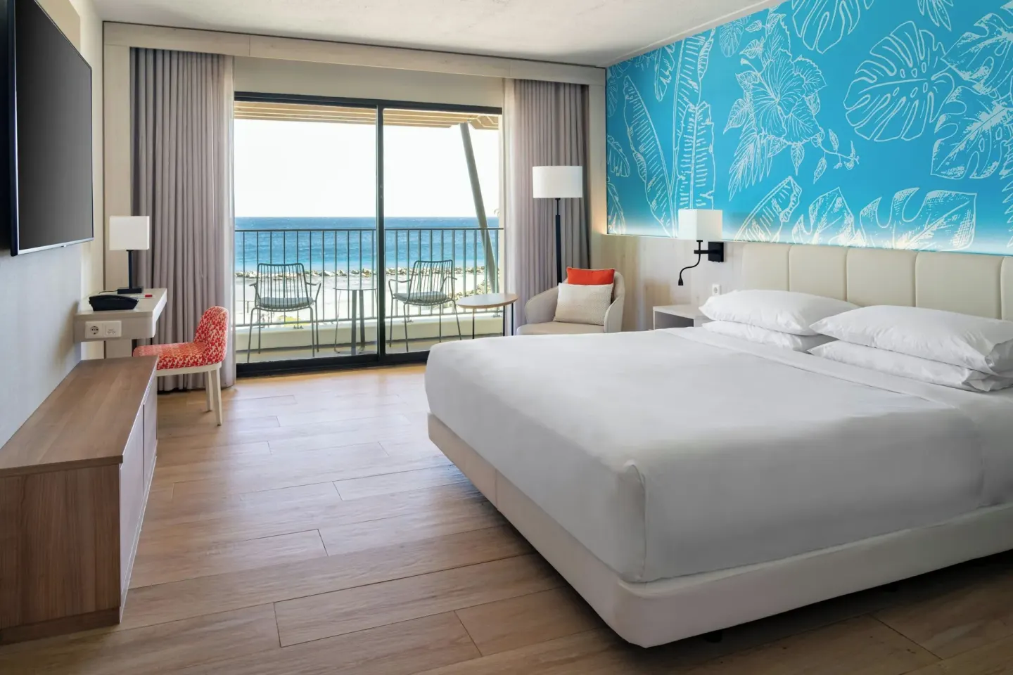 King bed oceanfront room at Curacao Marriott Beach Resort with balcony seating and sea view.