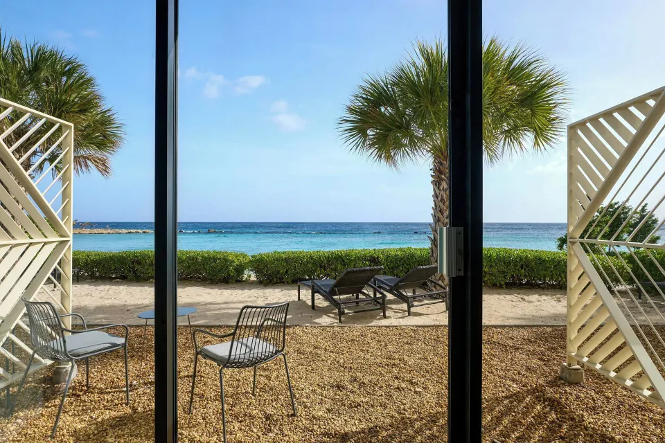 Oceanfront room patio at Curacao Marriott Beach Resort with chairs facing the beach and sea.