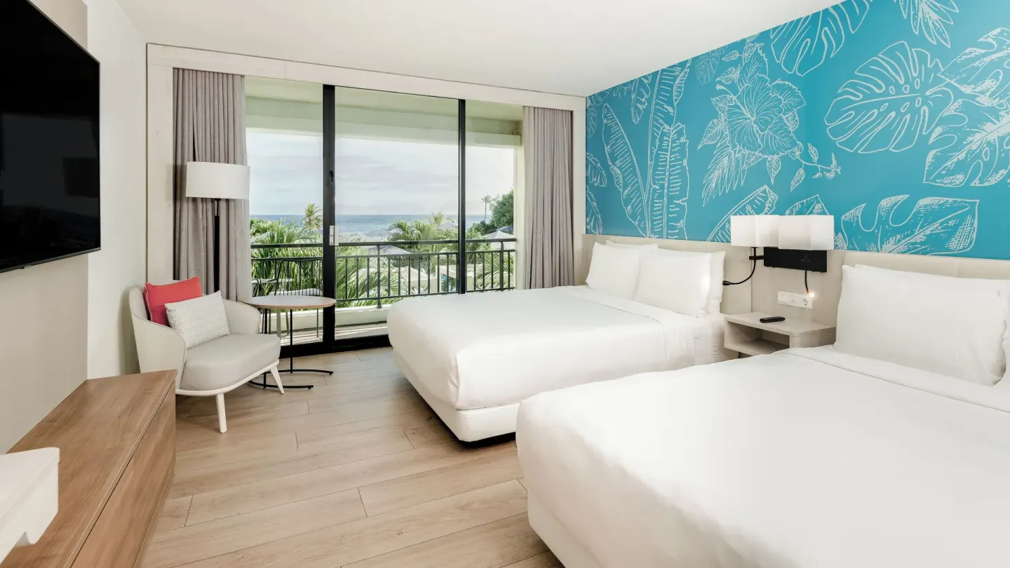 Two double beds and balcony with partial ocean view at Curacao Marriott Beach Resort.