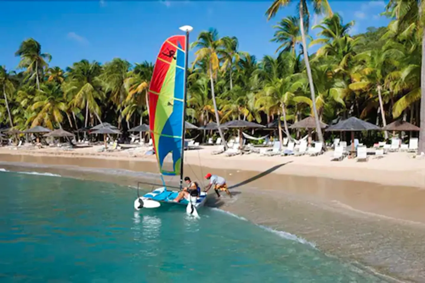 A colorful beach catamaran is launched from the shore at Curtain Bluff Resort.