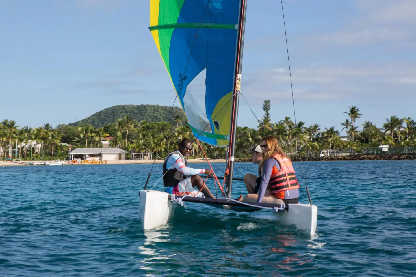 Guests sail a small catamaran off the beach at Curtain Bluff Resort.