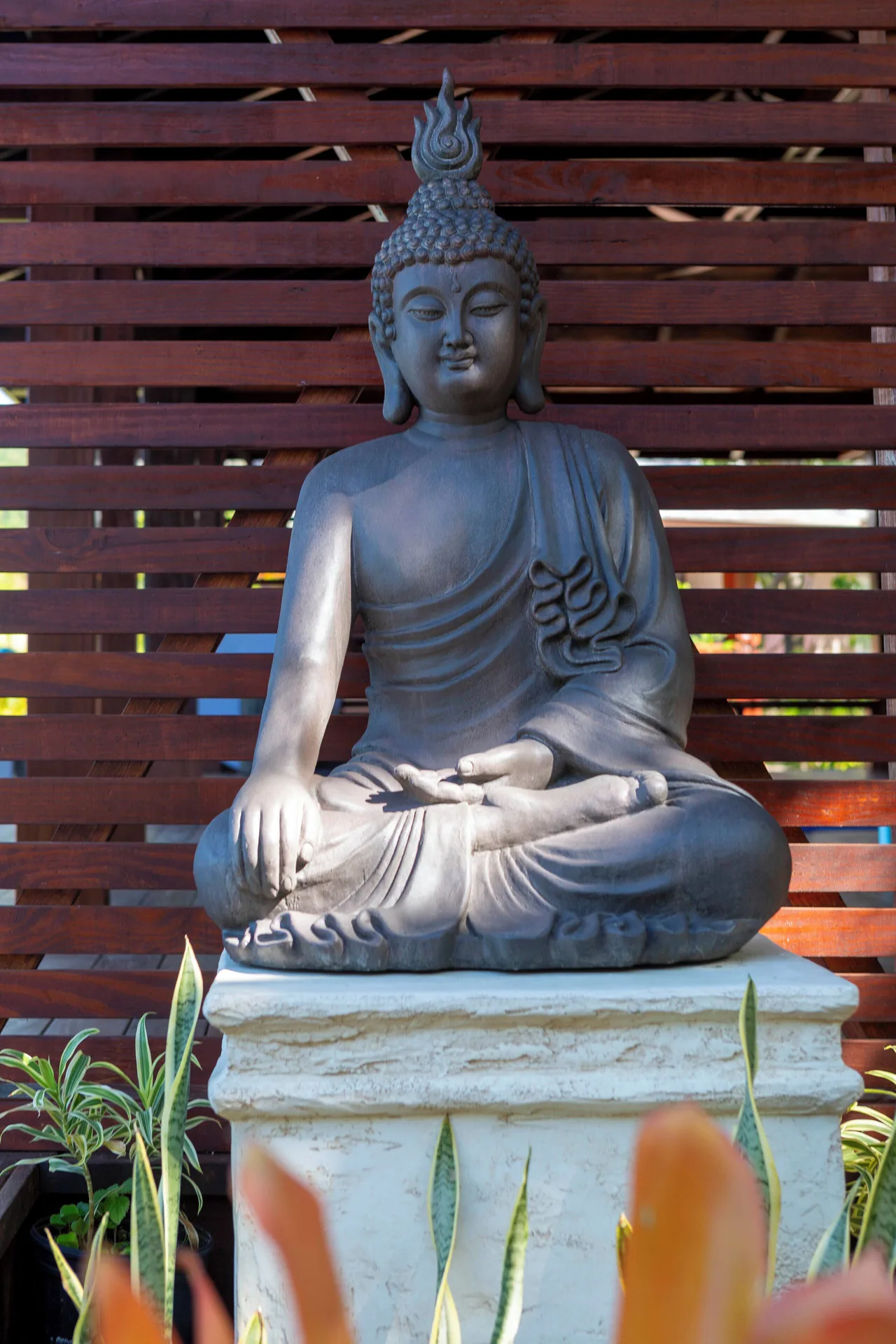 Seated Buddha statue in a garden setting at Curtain Bluff Resort.