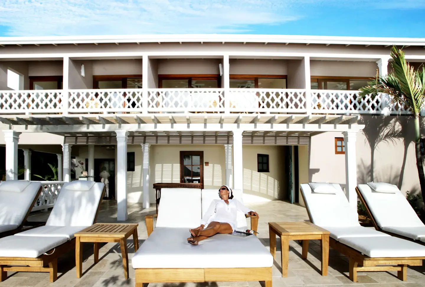 Sun loungers outside a two-story resort building at Curtain Bluff Resort.
