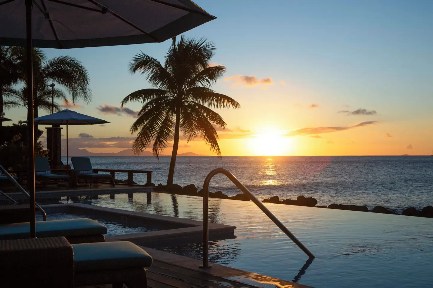 Sunset over the ocean beside the pool at Curtain Bluff Resort.