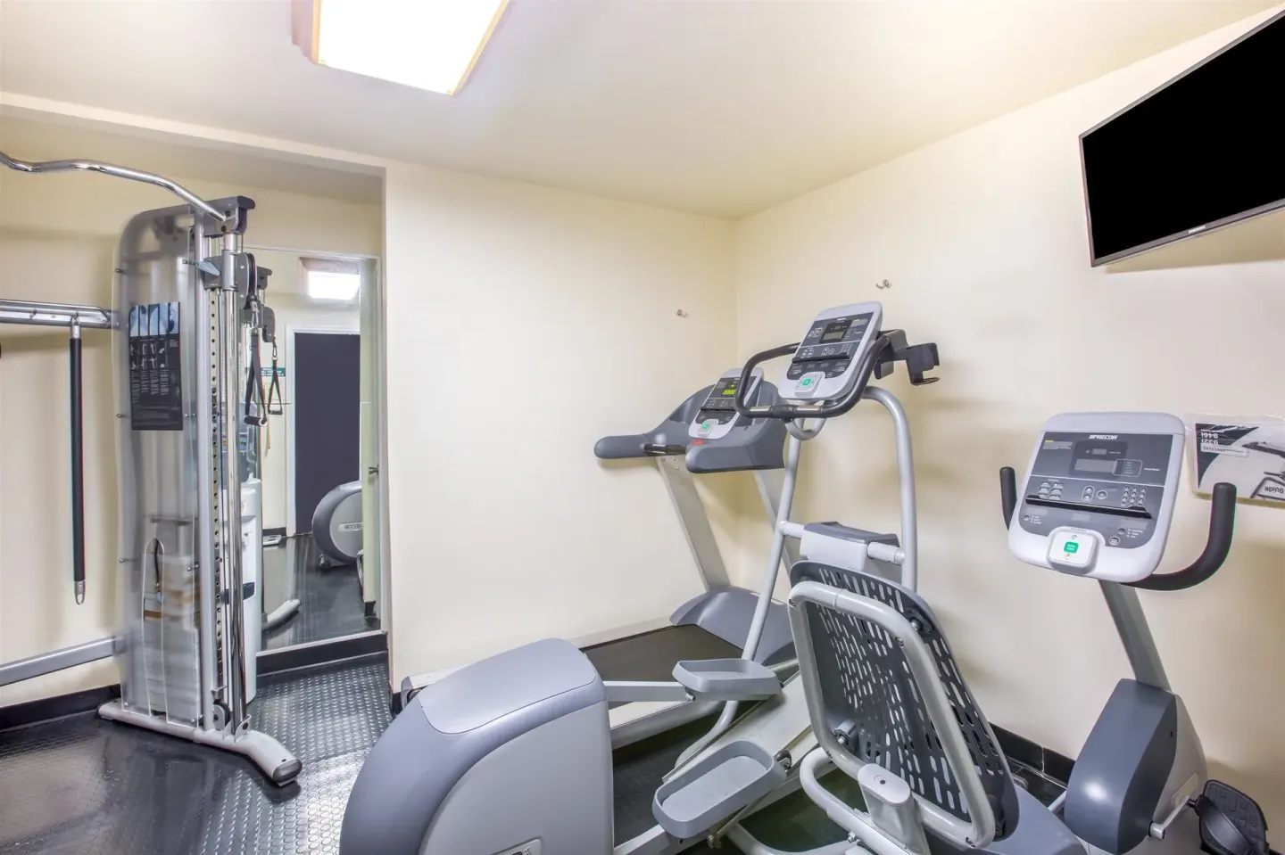 Fitness room with cardio machines and weight station at Days Inn Maui Oceanfront.