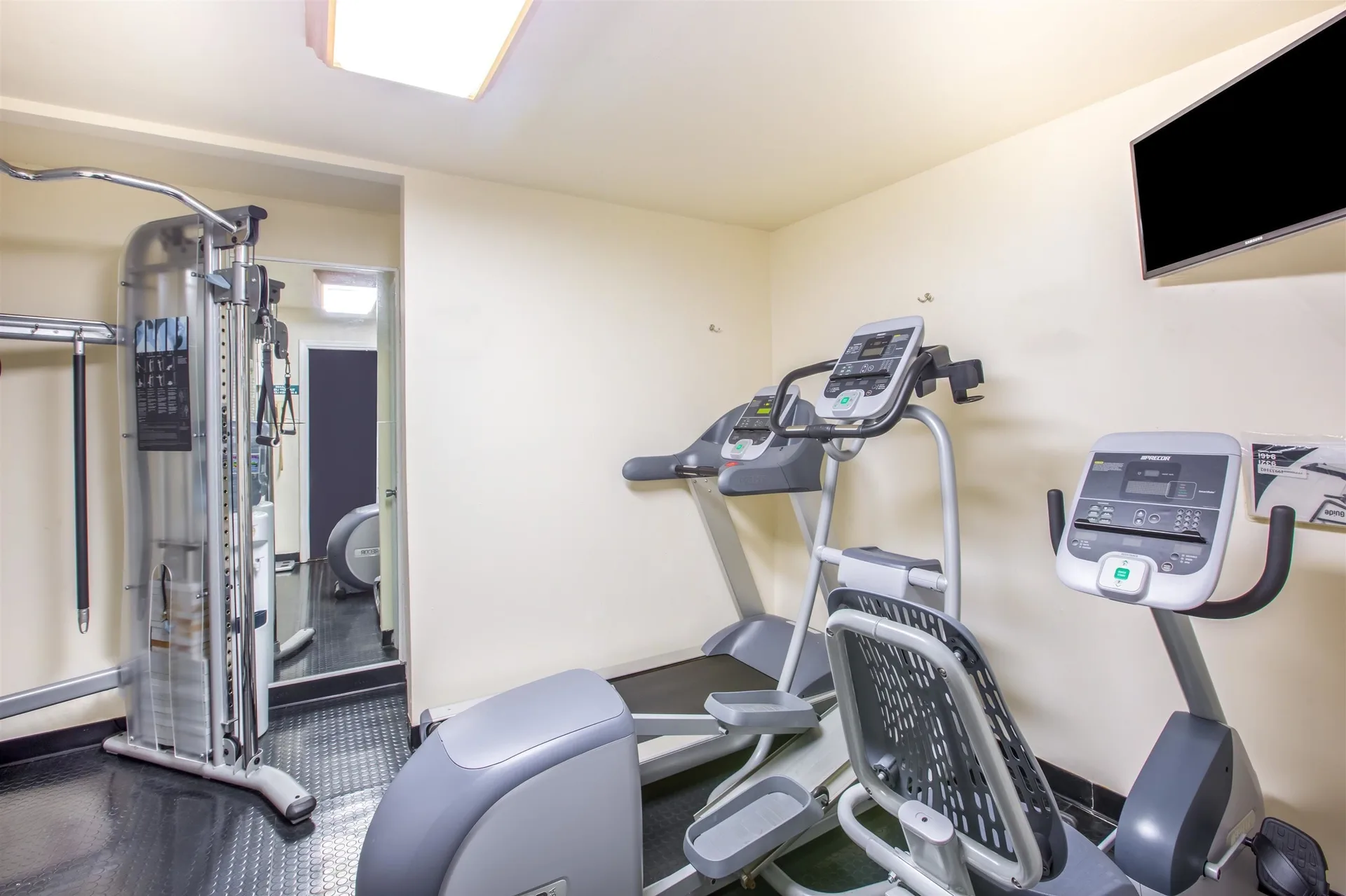 Fitness room with cardio machines and weight station at Days Inn Maui Oceanfront.