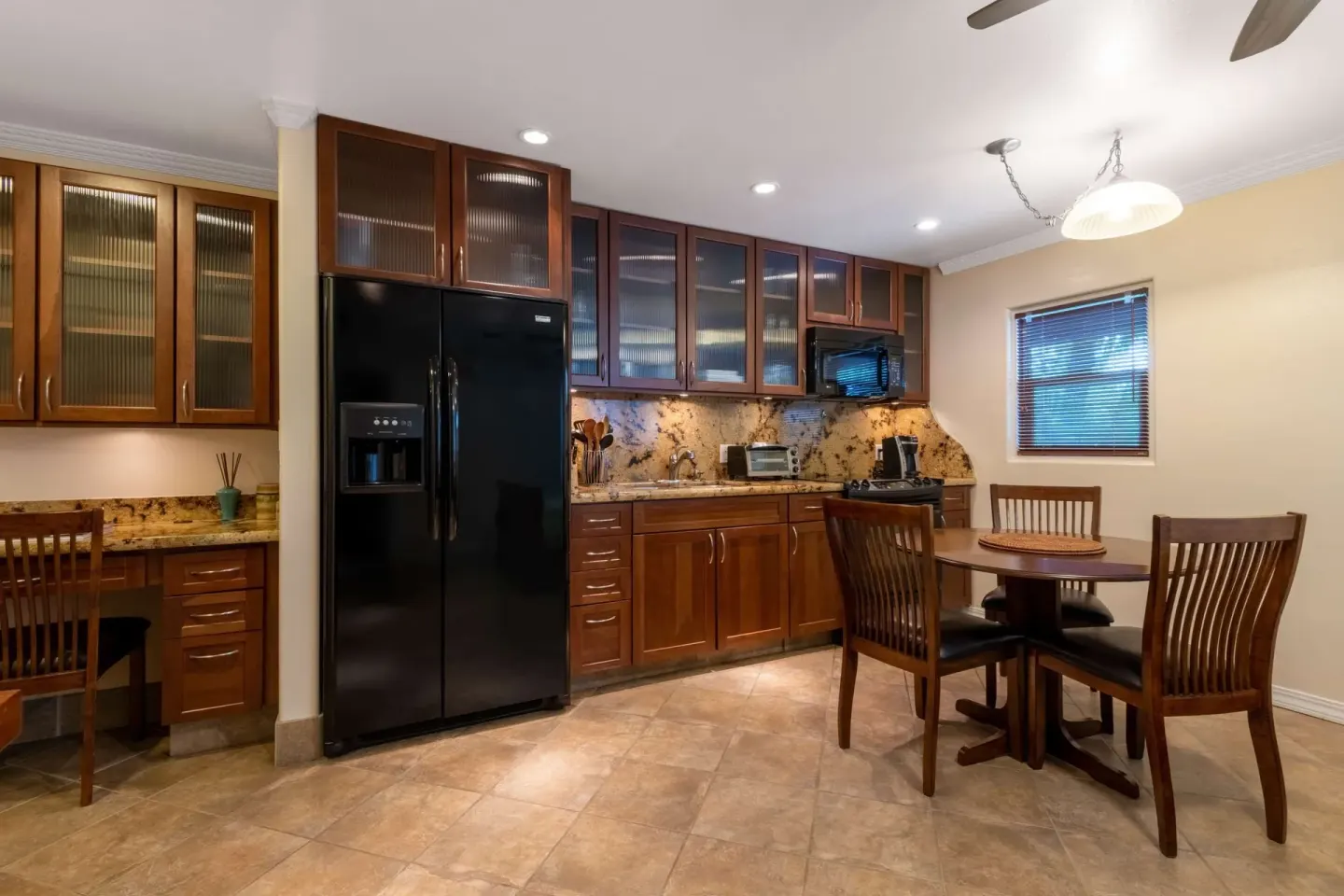 Kitchen with dining table and black refrigerator at Days Inn Maui Oceanfront.