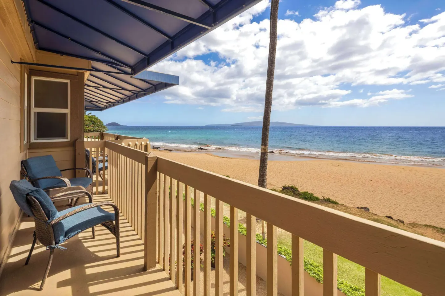 Oceanfront balcony with lounge chairs and beach view at Days Inn Maui Oceanfront.