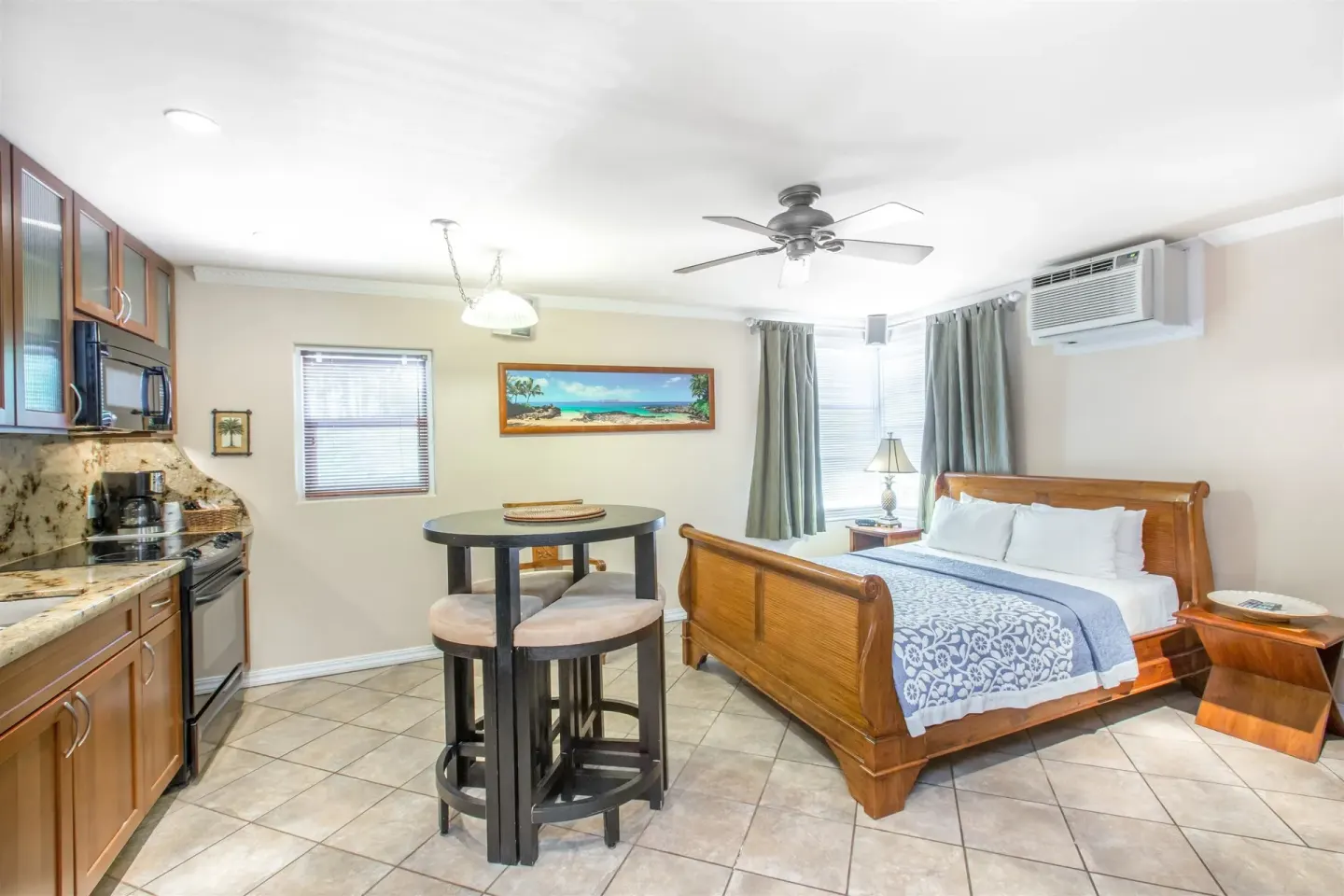 Kamehameha Studio Suite with bed, kitchenette, and dining table at Days Inn Maui Oceanfront.