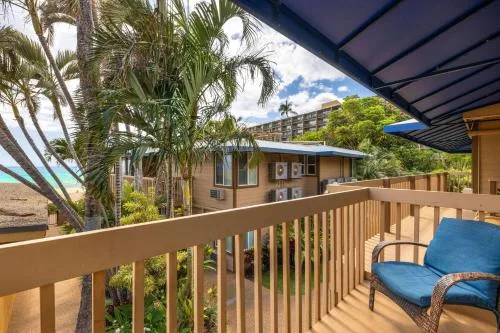 Covered room balcony overlooking palms and ocean at Days Inn Maui Oceanfront.